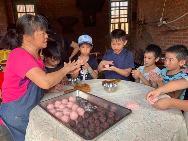 利用粿版压出红龟粿的样子。（传统聚落文化协会提供／谢明俊苗栗传真）