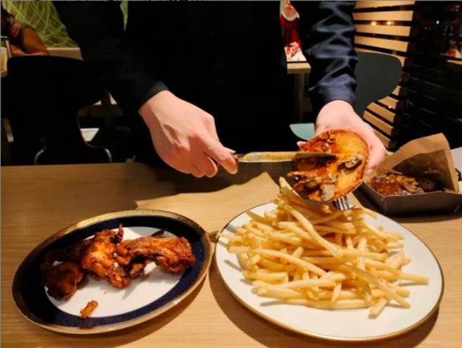 男友不慌不忙地拿出包包里的盘子跟刀叉，点餐完后，开始将汉堡里的松露酱挖出，并倒在鸡翅、薯条上。(摘自Dcard)