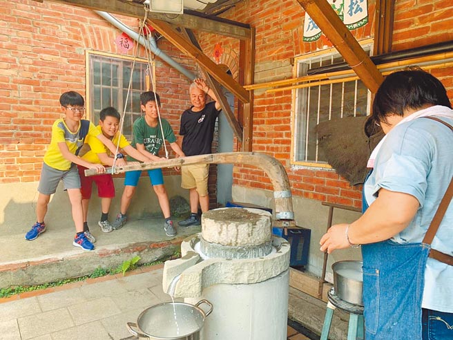 苗栗县头份芦竹湳传统聚落文化协会，指导民眾用传统石磨磨出米浆制成红龟粿。（传统聚落文化协会提供／谢明俊苗栗传真）