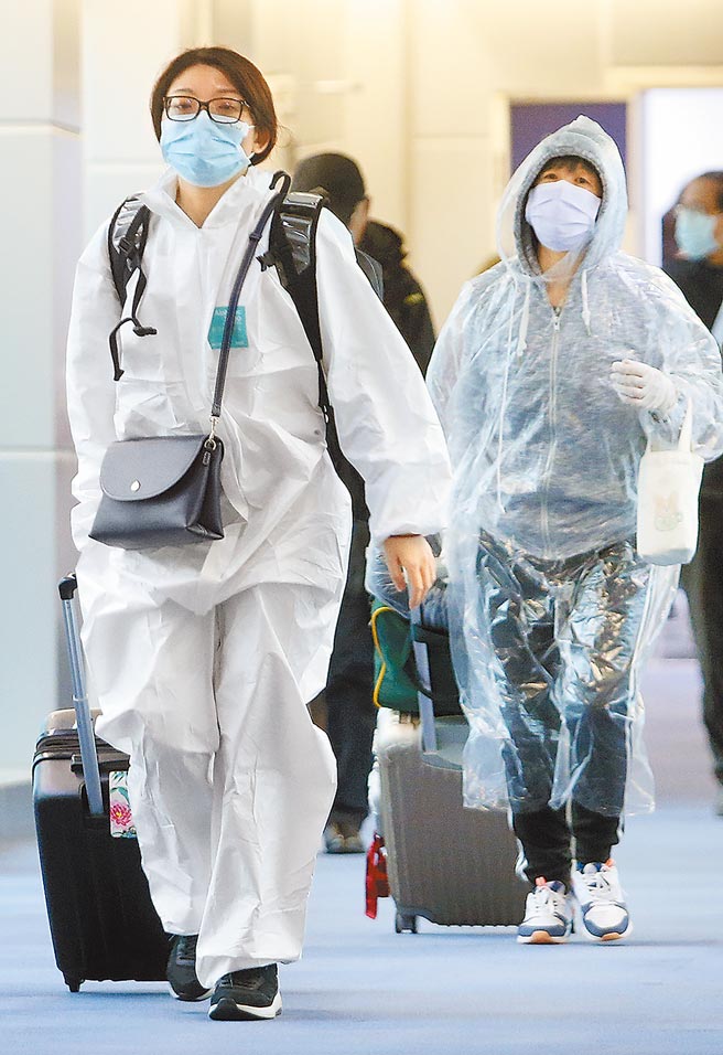 卫福部「秋冬防疫专案」英文新闻稿闹乌龙，害许多国人被国外机场拒绝核发登机证，而无法回国。图为在桃园机场入境管制区内，身穿防护衣的旅客正准备通关入境。（范扬光摄）