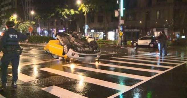 北市市民大道与光復南路口今凌晨发生一起小黄自撞翻覆车祸，计程车翻覆180度横躺在车道上，驾驶还受困其中。（图／翻摄画面）