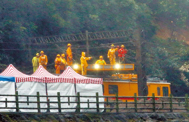 台铁瑞芳至猴硐间才刚修復的边坡，4日再度大片滑落，在坍方现场台铁工作人员全力抢通中。（赵双杰摄）