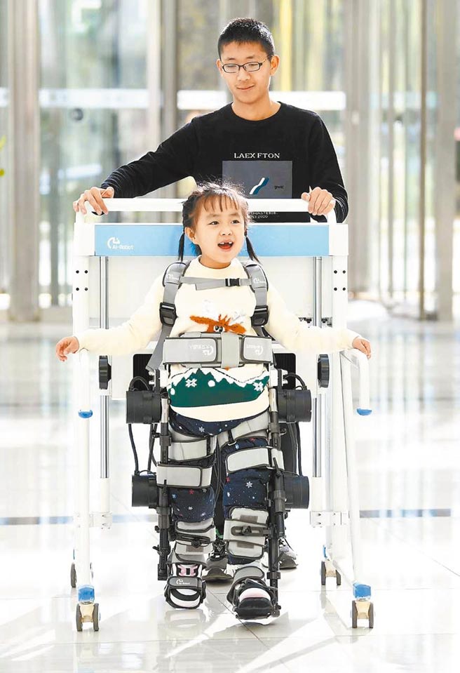 7歲的易諾已經在陽光大艾肢體殘疾人士康復中心治療數月，在外骨骼康復機器人的「幫助下」重新站立起來，笑容就綻放在她的小臉上。（和冠欣攝）