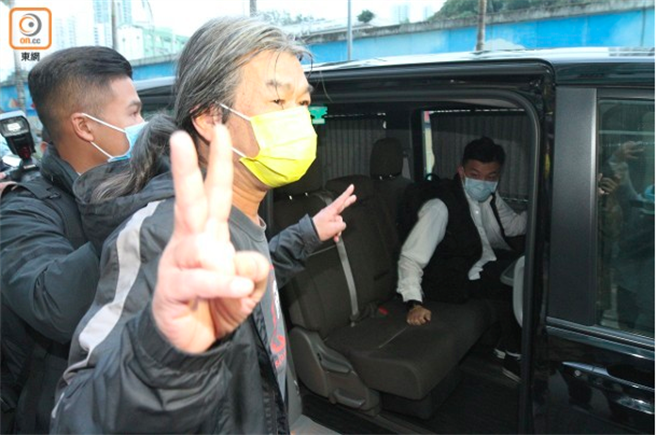 前立法會議員「長毛」梁國雄(黃色口罩者)被帶上警車。（東網）
