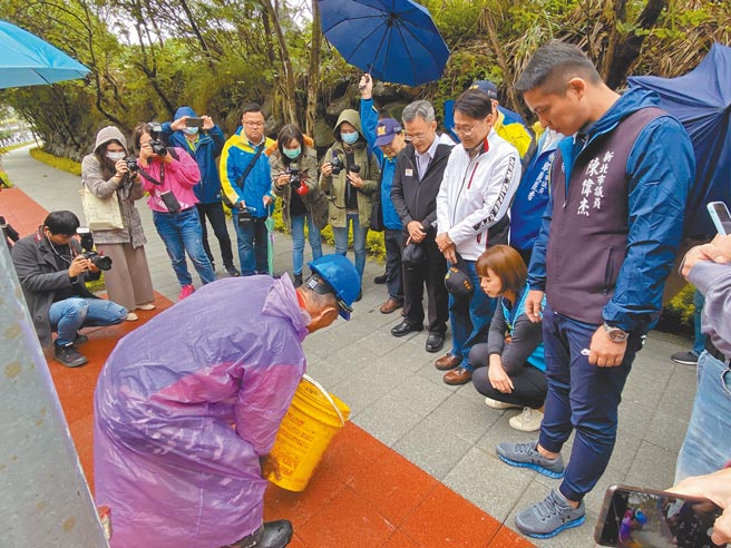 新北市副市长陈纯敬7日上午前往淡金路人行道视察，市府人员将一桶水泼在透水路面，水珠很快就渗入路面下，显示透水地面对环境的友善。（戴上容摄）