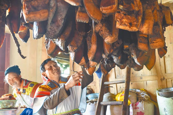大陆部分民眾认为时值入冬，南方开始腌制腊肉的需求是猪价上涨主因。图为贵州苗族人于农历过年前悬挂腊肉。（新华社资料照片）