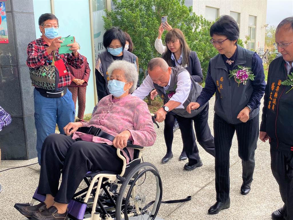 苗栗縣長徐耀昌推坐著輪椅老人家試乘新的巡迴醫療車。（巫靜婷攝）