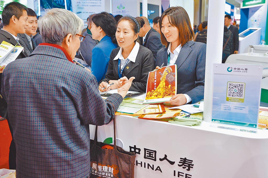 北京國際金融博覽會，一名參觀者在展區向工作人員諮詢保險業務。（新華社資料照片）