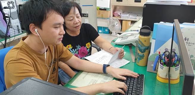 立明的同事美香主动伸援手，有时代替视障员为他报读，协助他处理业务。（卢金足摄）