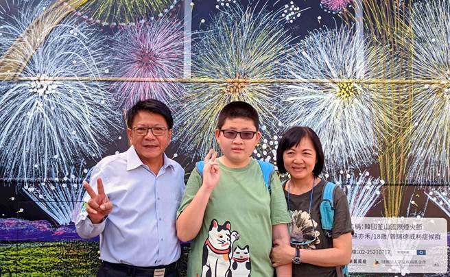 屏东县政府13日邀请66名小胖威利症病友及家属，搭乘「罕见疾病病友画作」艺术公车一日游屏东，病友苏亦禾（中）及妈妈，开心与县长潘孟安（左）在自己画作的公车前合影。（潘建志摄）