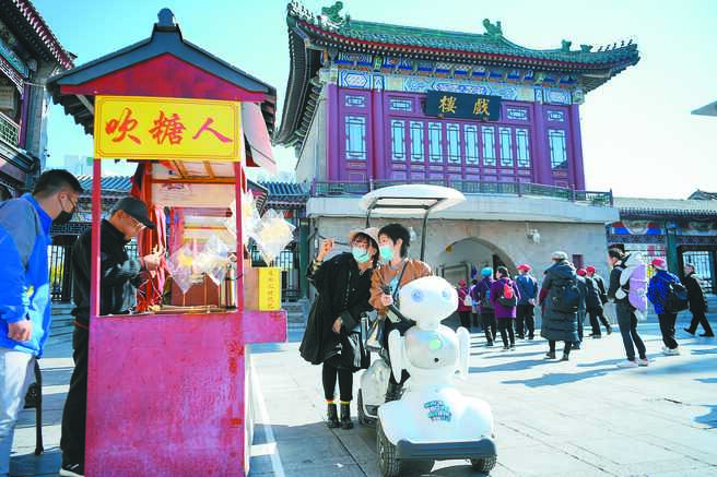 11月3日，游客乘坐智慧伴游机器人在天津古文化街景区内游玩。（中新社）