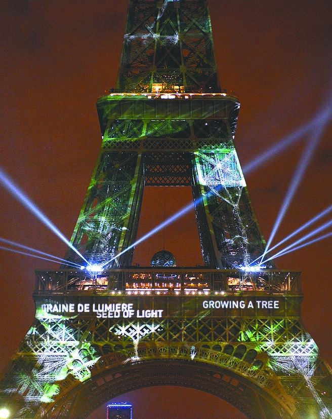 2015年11月29日，法國巴黎艾菲爾鐵塔披上綠裝，迎接氣候變化大會。（新華社）