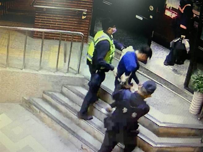 张姓男子（蓝衣低头者）与叶男相约在派出所对面的宾馆房间内吸毒遭逮。（读者提供／程炳璋台南传真）