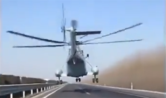 中方海军直–8直升机低空沿着高速公路飞行的画面。（网路）