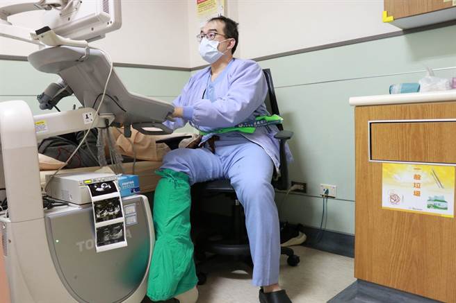 嘉义基督教医院妇产科医师王培中右脚做韧带重接手术，打着石膏坐在诊间看诊。（嘉基医院提供）