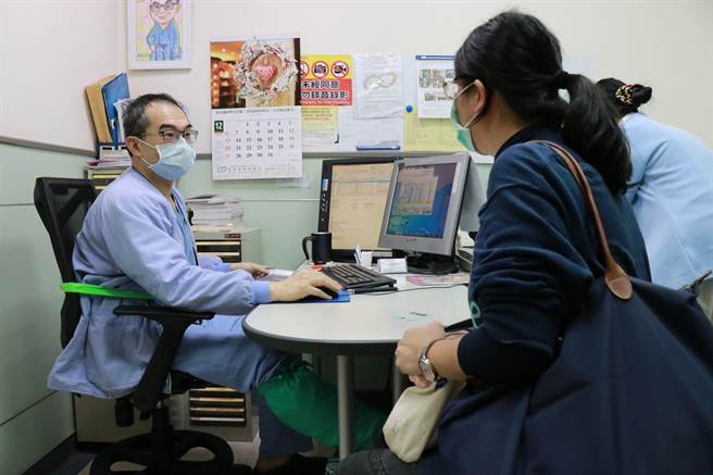 嘉基医院妇产科医师王培中打着石膏坐在诊间看诊。（嘉基医院提供）