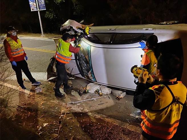 利用大型油压器材敲破前挡风玻璃，让受困2人安全脱离车子。（金门县消防局提供）