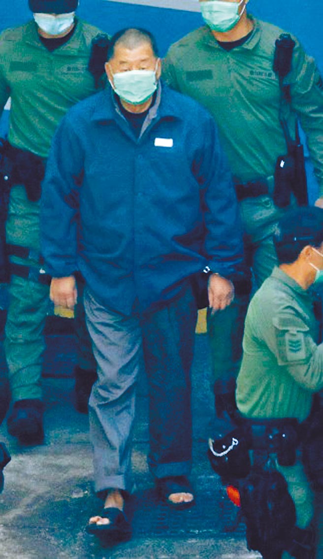 香港壹傳媒創辦人黎智英18日身穿藍灰色囚衣及拖鞋、雙手扣上手銬，被轉送赤柱監獄繼續收押。（東網提供）