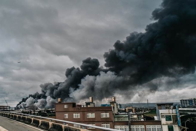 工厂爆炸后引发的一大片浓浓黑烟直窜天际，盘踞桃园国际机场北侧跑道上，班机只好穿越浓烟起飞。（郭吉铨摄）