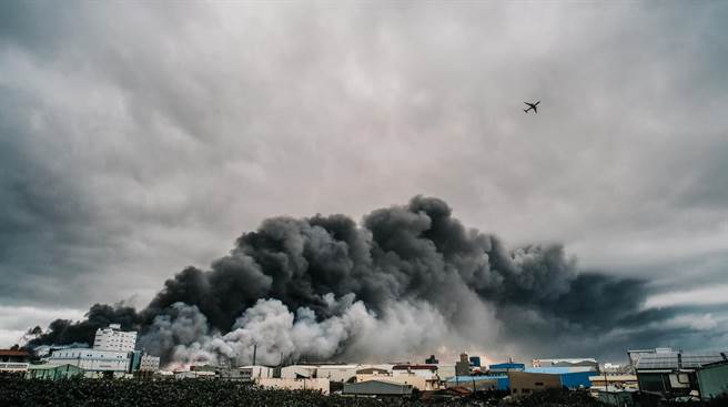 工厂爆炸后引发的一大片浓浓黑烟直窜天际，盘踞桃园国际机场北侧跑道上，班机只好穿越浓烟起飞。（郭吉铨摄）