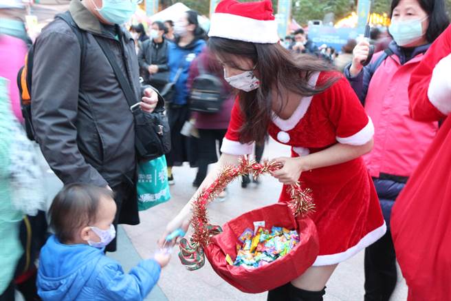 市府同仁装扮成圣诞老公公及耶诞女郎发放糖果。（许哲瑗摄）