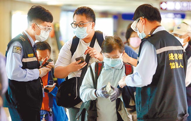 中央流行疫情指挥中心19日公布国内新增4例境外移入新冠肺炎确定病例，在桃园机场入境管制区内，防疫人员正协助旅客上网申报入境健康资料。（范扬光摄）