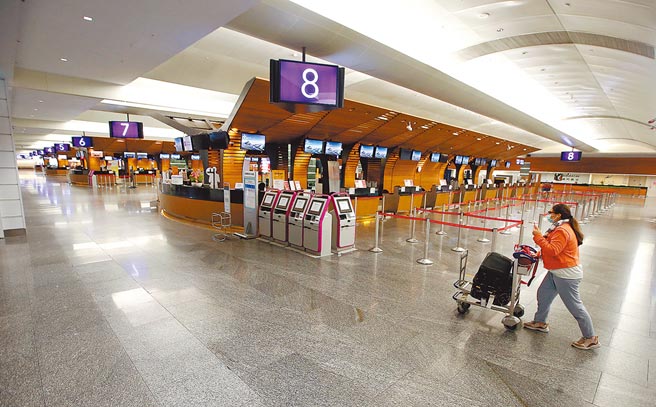 受新冠肺炎疫情影响，航空及观光相关产业严重受创，来台旅游观光客人数屡创新低，在桃园机场第一航厦中，1位旅客走过空荡荡的出境大厅。（范扬光摄）