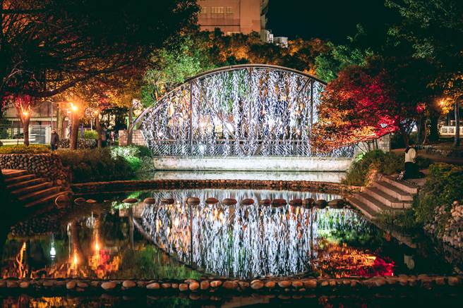 策展者游文富此次展出「白昼之叶」，以一整片垂挂式的白色树叶林，透过河面倒影交错，让民眾感受诗境氛围。（新竹市政府提供／陈育贤新竹传真）