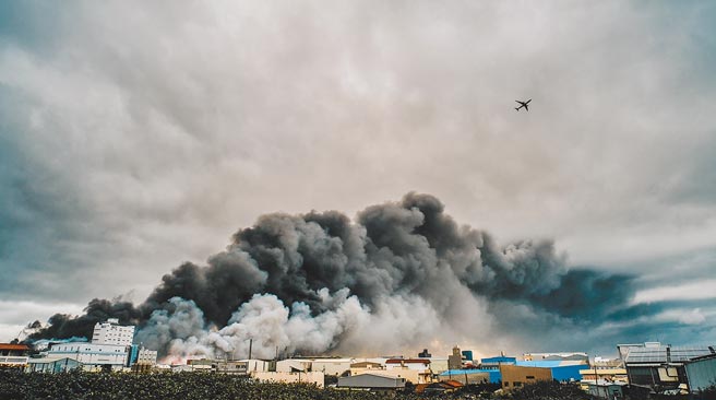 After the Xufu factory explosion, a large swath of thick black smoke erupted in the sky, barricading the northern runway of Taoyuan International Airport, and the flight had to go through smoke to take off.  (Photo by Guo Jiquan)