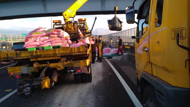 上百包的白米因为没有绑捆牢固，联结拖板车在彰化系统交流道弯道上转弯时，全甩落一地，白米瞬间宛如下雪撒满地。（警方提供／谢琼云彰化报导）