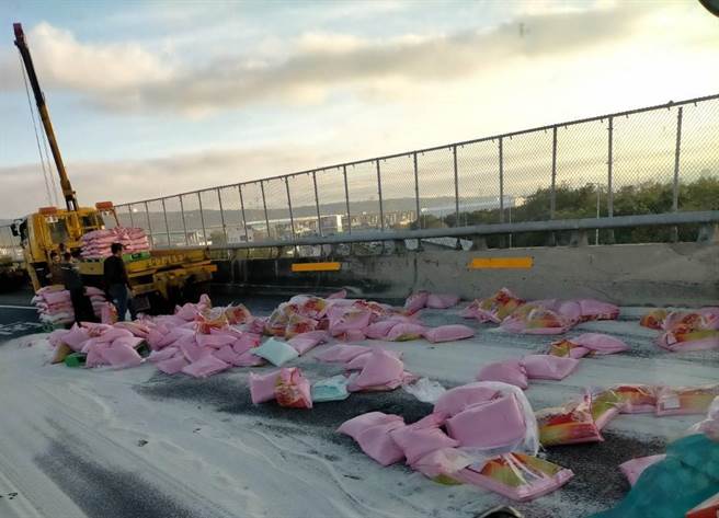 大量的白米撒落满地，让路过驾驶人直呼好可惜，国道警方指，业者未固定货物导致掉落将依法开罚，业者回收白米重新清理后将用于饲料用途。（摘自彰化踢爆网／谢琼云彰化报导）