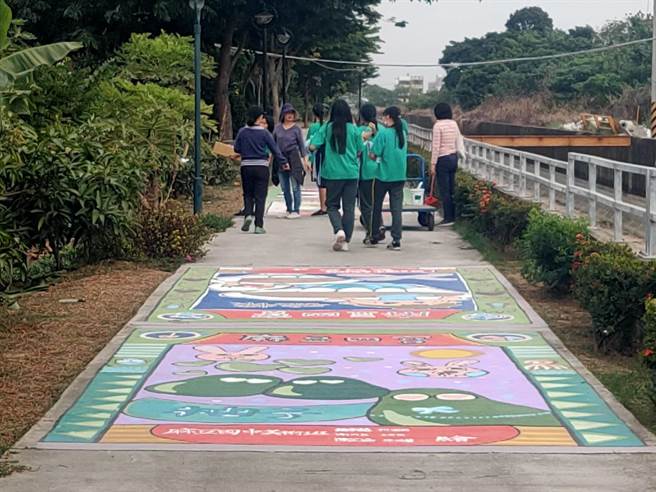 台南市麻豆区公所4年前在嘉南大圳旁休閒步道打造13幅彩绘，已经逐渐褪色，近来麻豆商圈争取经费、公所协调，由曾文家商、麻豆国中学子重新将彩绘上色，也创作出新图，让步道有新貌。（庄曜聪摄）