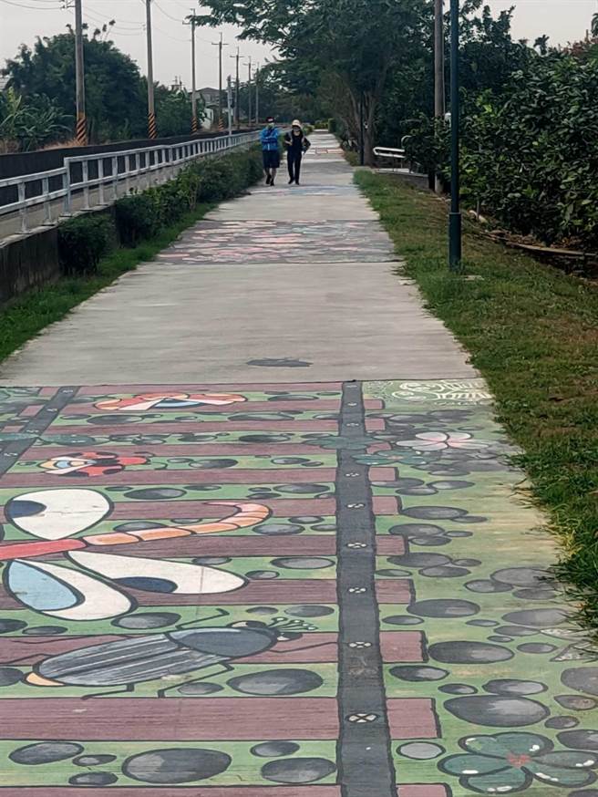 台南市麻豆区公所4年前在嘉南大圳旁休閒步道打造13幅彩绘，已经逐渐褪色，近来麻豆商圈争取经费、公所协调，由曾文家商、麻豆国中学子重新将彩绘上色，也创作出新图，让步道有新貌。（庄曜聪摄）