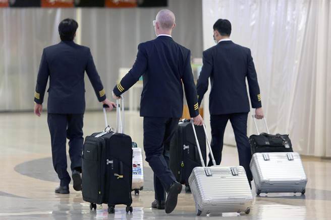 中央流行疫情指揮中心22日宣布增加一個本土病例，這也是台灣維持253天本土零確診之後，再次宣告出現本土病例。新增本土病例為長榮航空紐西蘭機師的友人，長榮航空表示，該位機長若違反防疫相關規定，規避及妨礙疫調，違規屬實將予以免職處分。圖為剛執飛結束準備回公司報到的長榮航空機師。（非新聞事件當事人）（陳麒全攝）