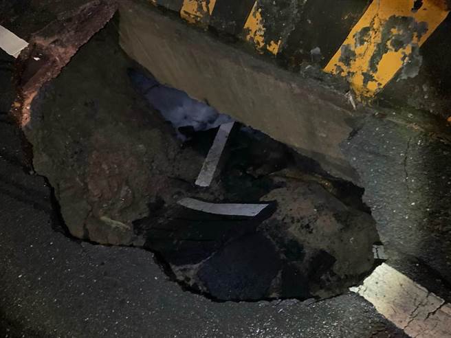 基隆市安樂區湖海路上坡處往武聖街巷口，有一路面無預警出現2米大坑洞，警方封鎖現場。（翻攝照片／陳彩玲基隆傳真）