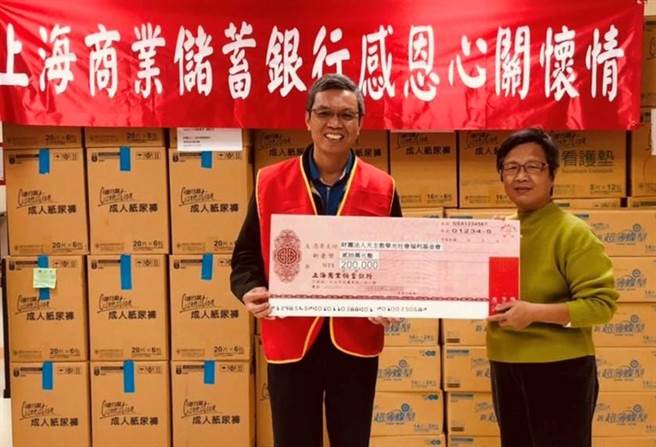 （上海商银资深副总经理彭国贵(左)代表该行捐赠20万元支票及物资，由华光秘书处副主任邹佳蓉代表接受。图／上海商银提供）
