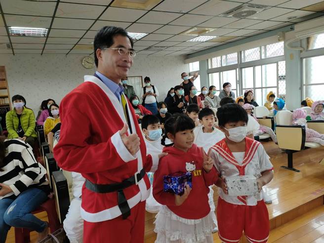 台南市大内区长李义隆（左）变身圣诞老公公发送礼物。（台南市二溪国小提供／刘秀芬台南传真）