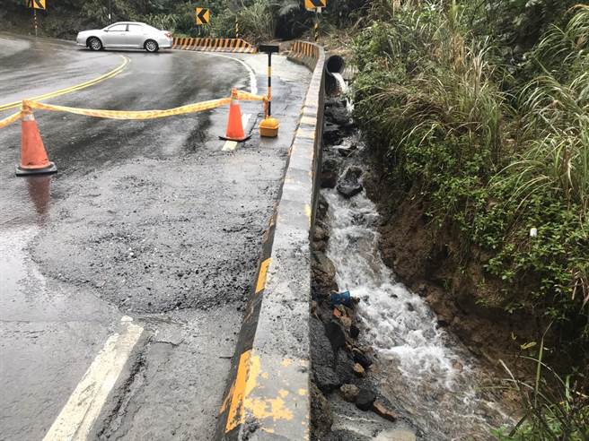 基隆市安乐区湖海路上22日晚上无预警出现2公尺深坑洞，一旁水流不断冲刷地基。（陈彩玲摄）
