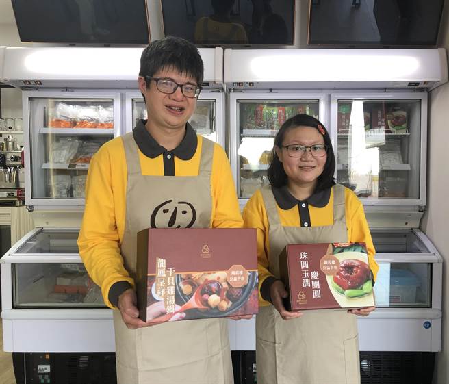 喜憨儿爱点心庇护工场推出「牛转钱坤」年菜礼盒，憨儿阿卿与小梅（右）展示年菜。（林雅惠摄）