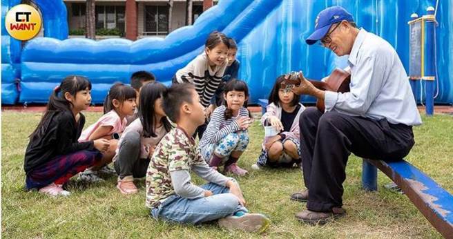 何茂成每次活动除了细心照护学童安全，閒暇时还会弹吉他高歌跟小朋友同乐。（图／宋岱融摄）