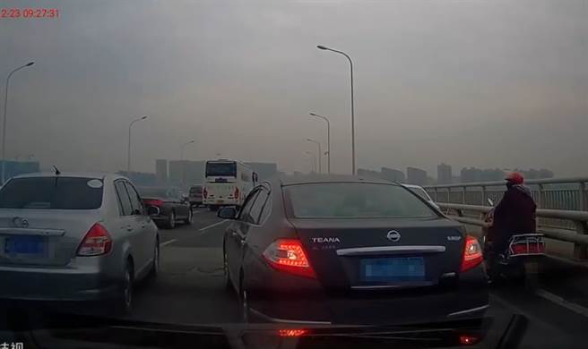 男子将白色小客车停在路上后寻死，后方车辆惨被卡住，目睹全程。(翻摄自微博)