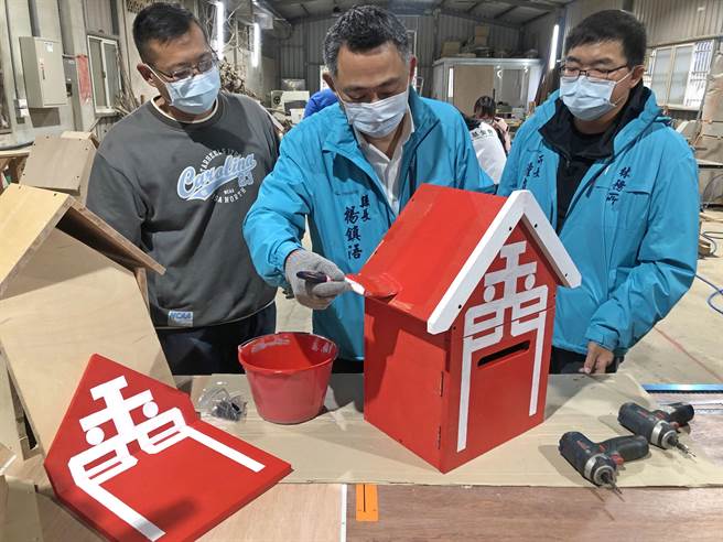 杨镇浯县长加入志工群，在木心板刷出象徵爱心的大红漆。（李金生摄）