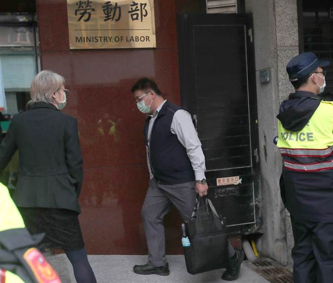 呼完口號後，五位出席的勞動基金監理會委員進入勞動部陳情。圖為莊慶文委員通過維安警力走入勞動部。（鄭任南攝）

