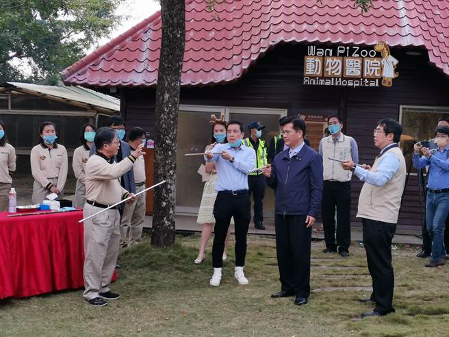 台南市学甲区顽皮世界野生动物园「环境教育中心」24日正式启用，交通部长林佳龙（右二）、台南市长黄伟哲（右一）挑战兽医师必备的吹箭麻醉技能。（刘秀芬摄）