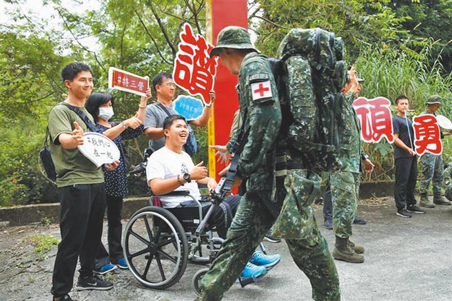 今年10月伞兵秦良丰（中）受邀「回娘家」，坐着轮椅现身特三营活动，令在场官兵感动不已。（撷取自陆军司令部脸书／柯宗纬高雄传真）