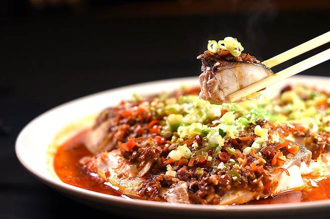 〈36美食〉的〈剁椒鱼头〉除了舖了灯笼椒与野山椒，蒸制时还加了自家发酵的剁椒酱，所以风味极富层次。（图／姚舜）