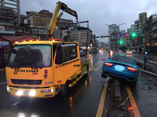 超狂玛莎拉蒂信义区硬跨分隔岛，撞倒灯杆车头半毁。(戴志扬翻摄)