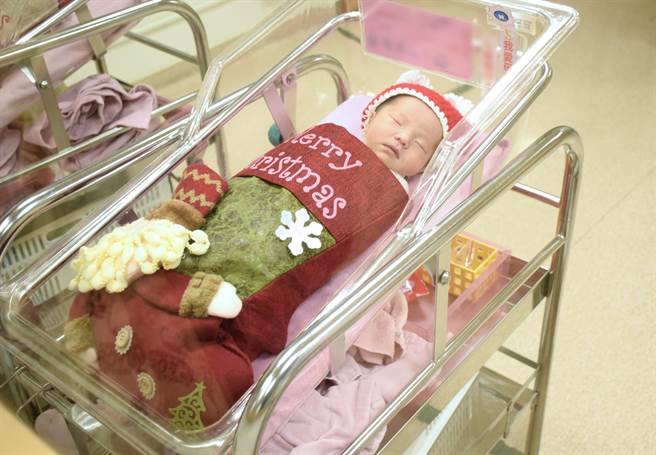 亚东医院为刚出生的宝宝们穿上可爱圣诞装，每个宝宝在婴儿床上戴上圣诞帽，身体套进圣诞袜里，模样相当可爱。（图／亚东医院提供）