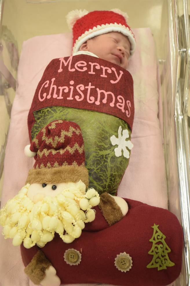 亚东医院为刚出生的宝宝们穿上可爱圣诞装，每个宝宝在婴儿床上戴上圣诞帽，身体套进圣诞袜里，模样相当可爱。（图／亚东医院提供）