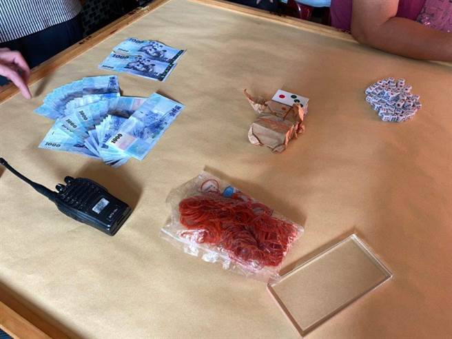 高雄市鸟松区一家汽车旅馆疑沦为职业赌场赌博据点，警方前往取缔，赫见旅馆房间有天九纸牌5付、骰子65颗及无线电对讲机等设备，起获赌资新台币2万元、抽头金新台币2000元。（警方提供／林雅惠高雄传真）